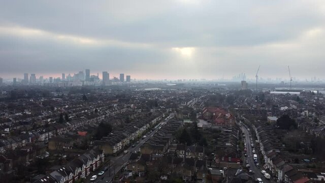 Residential terraced houses in London with skyscrapers in distance. Aerial view
