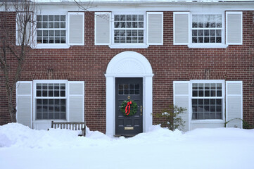 Traditional brick house with white shutters in winter