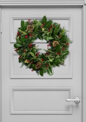 Christmas wreath with toys on a white wooden door. New year and christmas concept