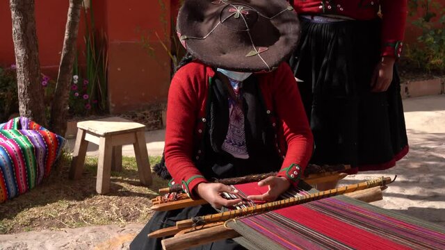 Peruvian Weaves Multi-colored Fabrics in Sacred Valley, Peru - tilt up shot