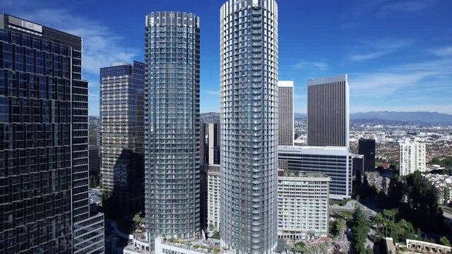 Pullback aerial, Century City skyscraper offer buildings on a clear blue day