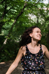 Naklejka premium Beautiful woman with curly hair, half of her face is hidden behind tree. Unity with nature.