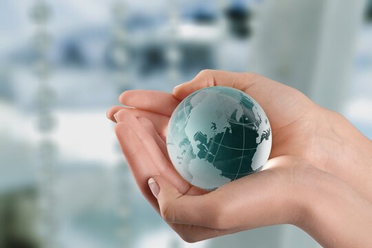 Globe model in hands on background. Save the world, planet Earth concept.