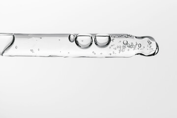 Transparent pipette with cosmetics on a white isolated background.