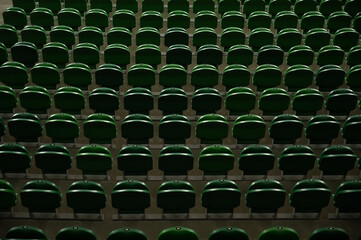 Empty stadium tribune with green seats.