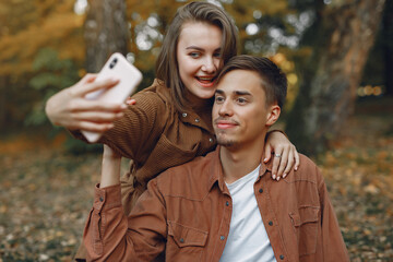 Fototapeta premium Beautiful couple spend time in a autumn park