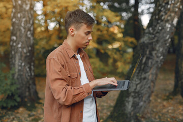 Student working in a park and use the laptop