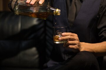 Man wearing a suit whiskey glass of liquor 