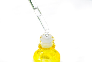 Dropping serum collagen moisturizer of face into clear yellow bottle soft light background. Protector skin Treatment facial essence oil, Vitamin C. Beauty and spa Concept
