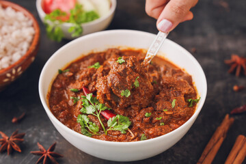 Traditional homemade Mutton curry from Asian cuisine Chukhandar gosht woman hand eating serving spicy meat beef curry coconut mutton roast Indian spices. side dish Ghee rice Appam Parotta