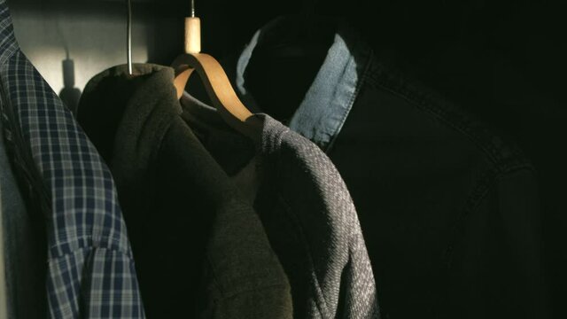 Closeup - Man takes shirt in the wardrobe at sunny morning at home.Morning get ready for work concept.