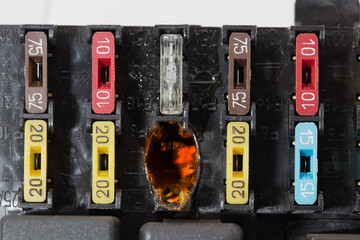 Burnt electrical contacts in the car fuse box. On the body of the unit, the designations of...