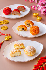 Obraz na płótnie Canvas A traditional French savory choux dough cheese puff plating on white plate with CNY decoration. pastry ball filled with whipped cream, choux pastry shells are filled withwith smooth and soft cream.