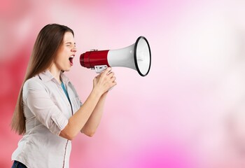 a beautiful excited young woman shouting holding a megaphone