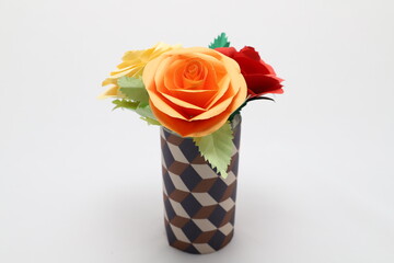 Fototapeta na wymiar 折り紙で作ったバラの花をカラフルなグラスに飾った様子