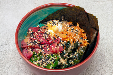 poke salad with tuna is a traditional food of Hawaiian and Japanese cuisine, in a plate, in the middle of the frame.