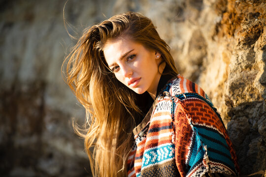 Beautiful woman in boho style sweater. Beautiful young woman wearing fashionable spring clothes. Portrait of the fashion model in trendy dress.