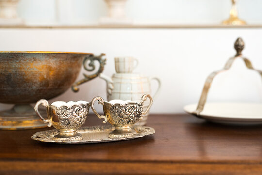Interior detail with antique cabinet and exquisite ceramic, glass and metal dishes - selective focus