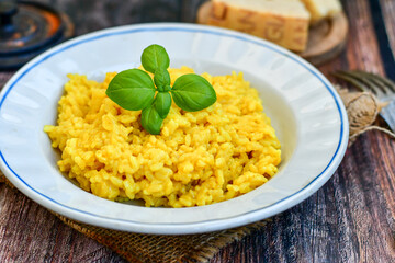  Italian  creamy risotto milanese  with parmesan cheese and fresh basil on rustic background
