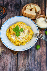  Italian  creamy risotto milanese  with parmesan cheese and fresh basil on rustic background