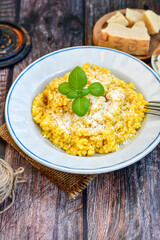  Italian  creamy risotto milanese  with parmesan cheese and fresh basil on rustic background