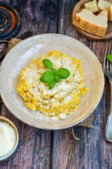  Italian  home made  creamy risotto milanese  with parmesan cheese and fresh basil on rustic background