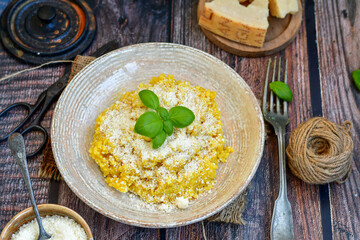  Italian  home made  creamy risotto milanese  with parmesan cheese and fresh basil on rustic background