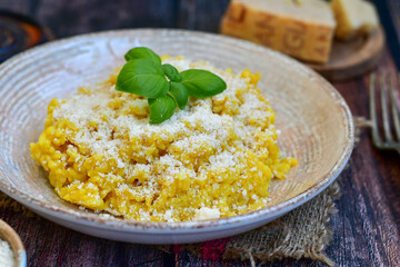  Italian  home made  creamy risotto milanese  with parmesan cheese and fresh basil on rustic background