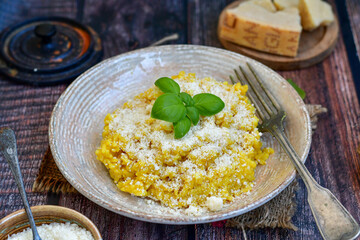  Italian  home made  creamy risotto milanese  with parmesan cheese and fresh basil on rustic background
