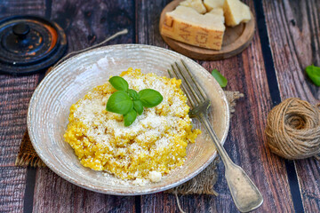  Italian  home made  creamy risotto milanese  with parmesan cheese and fresh basil on rustic background
