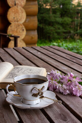 Spring still life scene. Artistic composition with cup of hot aromatic morning coffee and Floral...