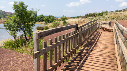 Fototapeta na wymiar wooden pathway pedestrian bridge entrance lake lac du Salagou in France