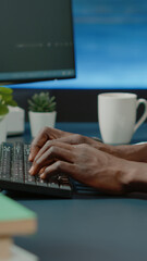Close up of black hands coding server interface with binary codes on computer. African american...