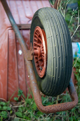 An old abandoned Rusty Wheelbarrow upside down in a garden