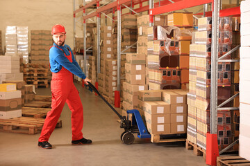 Worker with pallet jack at warehouse. Logistics center