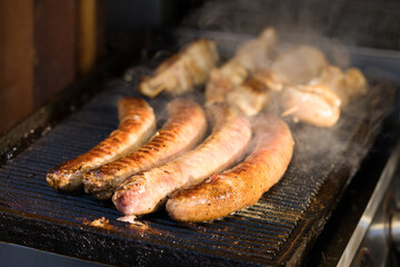 Closeup view of delicious grilled and fried sausages. Street food at local market of traditional festival, street food market vendor