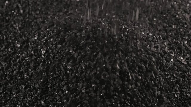 sprinkling black coconut charcoal close-up slo-mo, activated carbon small fraction
