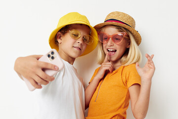 children in hats with phone together friendship