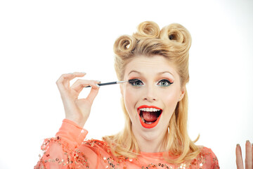 Eyebrow makeup. Blonde excited woman brushing brows with brows brush closeup. Pin up style.