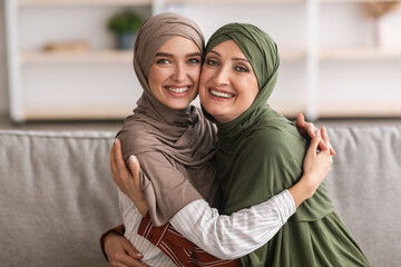 Cheerful Senior Middle-Eastern Mother And Adult Daughter Embracing At Home