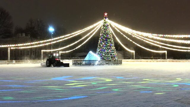 tractor cleaning ice from now on ice rink decorated and illuminated for christmas. Footage with noise effect