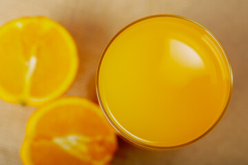 Shot from above glass of juice with oranges.