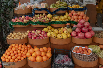 Fototapeta na wymiar Grocery store with christmas decorations. Quince, apple, orange, tangerine, banana, pomegranate.