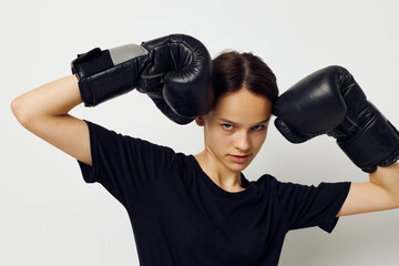 athletic woman in boxing gloves in black pants and a T-shirt fitness training