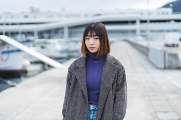 Obraz premium 港を散策する若い女性
