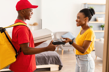 African American Lady Paying Deliveryman For Pizza With Smartphone Indoor