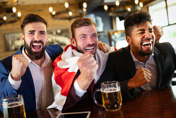Business men in pub cheering for a sporting event