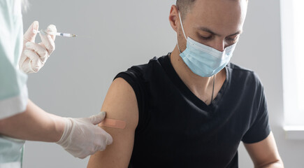 COVID-19 vaccine injection, doctor in gloves holds syringe and makes jab to woman patient in clinic. Prevention of coronavirus or influenza. corona virus and flu shot, therapy and treatment. - obrazy, fototapety, plakaty