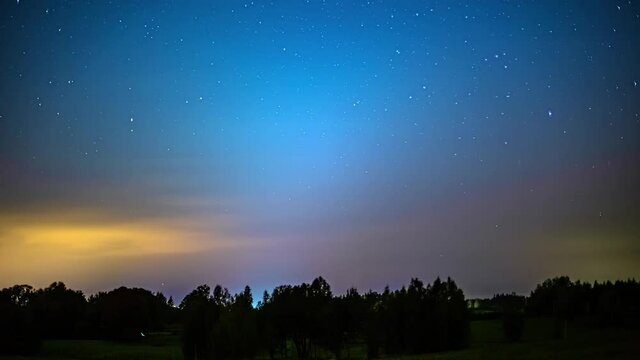 Time-lapse of stars in the night sky with a silhouetted nature skyline