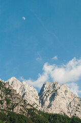 Alpine mountain range with blue sky and a moon